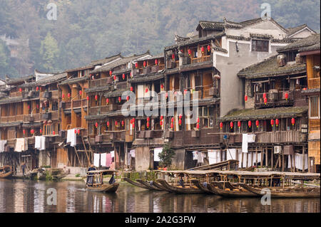 Hunan, Cina, 14 Nov 2011: uomo a remi in barca di legno lungo il fiume della antica strada. Foto Stock