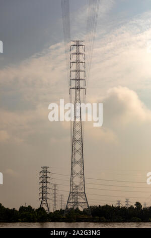 Massicce torri portando ad alta tensione e linee elettriche ad alta tensione nelle zone rurali del Vietnam Foto Stock