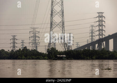Massicce torri portando ad alta tensione e linee elettriche ad alta tensione nelle zone rurali del Vietnam Foto Stock