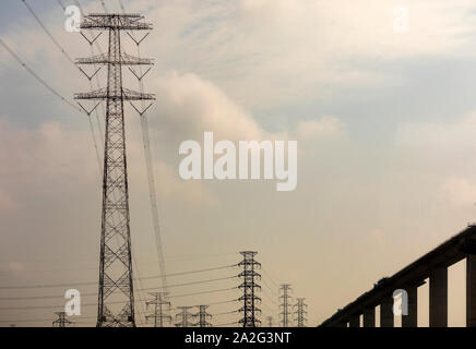 Massicce torri portando ad alta tensione e linee elettriche ad alta tensione nelle zone rurali del Vietnam Foto Stock