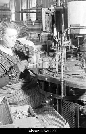 Eine Mitarbeiterin bei der Produktion von Leuchtröhren, Deutschland 1930er Jahre. Un personale femminile memmber produrre tubi fluorescenti, Germania 1930s. Foto Stock