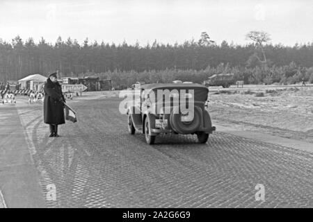 Ein Verkehrsposten leitet den Zivilverkehr um für den Weltrekordversuch mit dem Mercedes Benz W 125, Deutschland 1930er Jahre. Un poliziotto bypassando il traffico civile per il record mondiale di prova con la Mercedes Benz W 125, Germania 1930s. Foto Stock