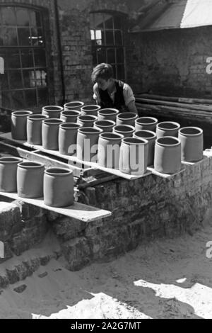 Zu brennende Tontöpfe auf dem Hof einer Töpferei im Dorf Görzke nel Brandeburgo, Deutschland 1930er Jahre. Pentole per essere bruciato in cortile di una ceramica presso il villaggio di Goerzke nel Brandeburgo, Germania 1930s. Foto Stock