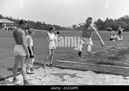 Übung im Weitsprung auf dem Sportplatz des KdF Sportheim Belzig in der Mark Brandenburg, Deutschland 1930er Jahre. Salto in lungo esercizio presso il campo sportivo dello sports club house a Belzig nel Brandeburgo, Germania 1930s. Foto Stock