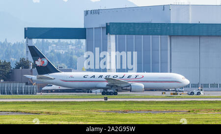 CargoJet Boeing 767-3ER (C-GVIJ) trainato da un rimorchiatore all'aeroporto internazionale di Vancouver. Aeroporto. Foto Stock