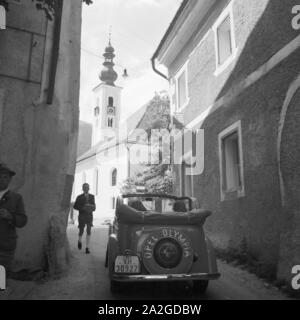 Mit dem Opel Olympia durch enge Gassen einer Gemeinde in Österreich, 1930er Jahre. Attraverso le strette viuzze con un modello Opel Olympia, Austria 1930s. Foto Stock