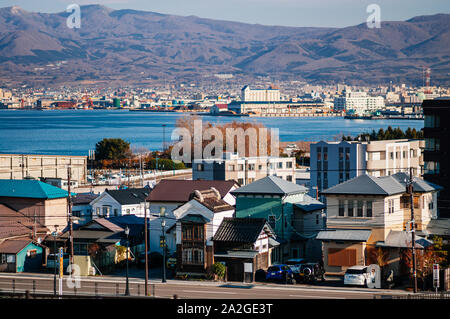 Dicembre 2, 2018 Hakodate, Giappone - Hakodate blu baia del porto e la città di edifici residenziali con vista montagna e cielo blu. Visto da di Motomachi park i Foto Stock