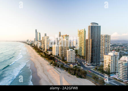 Antenna di sunrise skyline proprio sulla spiaggia. Bella la luce del mattino sulla Gold Coast holiday hotel destinazione dall'oceano. Foto Stock