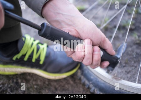 Voce maschile si gonfia la ruota di bicicletta con una pompa. Close-up Foto Stock