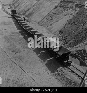 Ein Zug mit Kipplorenwagen beim Bau der Reichsautobahn, Deutschland 1930er Jahre. Un convoglio di camion per aiutare alla costruzione dell'autostrada Reichsautobahn, Germania 1930s. Foto Stock