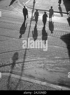 Die Menschen in Berlin werfen lange Schatten, Deutschland 1930er Jahre. persone in una strada di Berlino con le loro ombre, Germania 1930s. Foto Stock