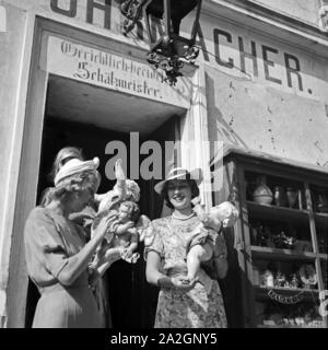 Drei junge Frauen haben in einem Uhrmachergeschäft Kunsthandwerksgegenstände eingekauft, Österreich 1930er Jahre. Tre giovani donne hanno comprato alcuni oggetti di artigianato in un orologio maker's shop, Austria 1930s. Foto Stock