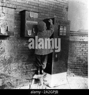 Ein kleiner Junge bringt einen breve zum Briefkasten, Deutschland 1920er Jahre. Un ragazzino di portare una lettera alla cassetta delle lettere, Germania 1920s. Foto Stock