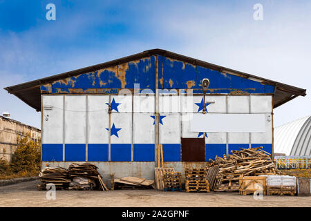 Close-up della bandiera nazionale di Honduras dipinta sulla parete metallica di un grande magazzino il territorio chiuso su un giorno d'estate. Il concetto di spazio di archiviazione Foto Stock