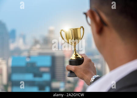 Sottolineato imprenditore con testa in mani nel suo ufficio Foto Stock