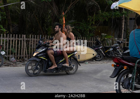 Un uomo e una donna sulla moto atto a trasportare le tavole da surf vicino al Cloud 9,Siargao,Filippine Foto Stock