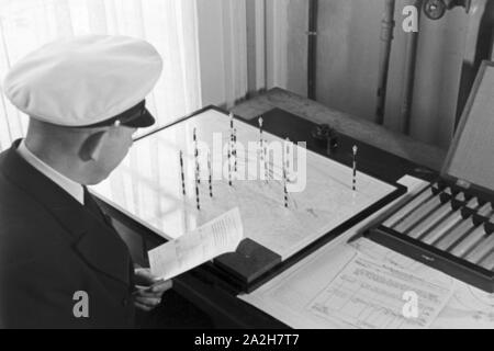 Mitarbeiter der Wetterdienststelle beim Sichten von Landkarten, Deutschland 1930er Jahre. Membro del personale di un ufficio meteorologico lavora con mappe, Germania 1930s. Foto Stock