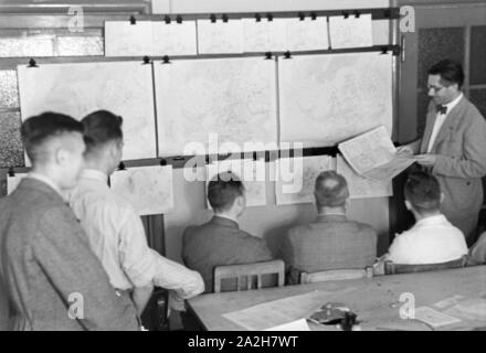 Mitarbeiter der Wetterdienststelle beim Sichten von Landkarten, Deutschland 1930er Jahre. Membro del personale di un ufficio meteorologico lavora con mappe, Germania 1930s. Foto Stock
