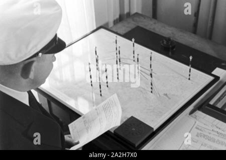 Mitarbeiter der Wetterdienststelle beim Sichten von Landkarten, Deutschland 1930er Jahre. Membro del personale di un ufficio meteorologico lavora con mappe, Germania 1930s. Foto Stock
