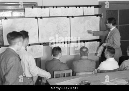 Mitarbeiter der Wetterdienststelle beim Sichten von Landkarten, Deutschland 1930er Jahre. Membro del personale di un ufficio meteorologico lavora con mappe, Germania 1930s. Foto Stock