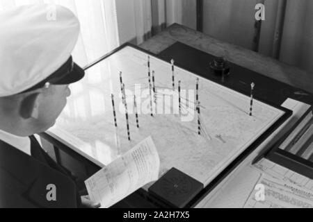Mitarbeiter der Wetterdienststelle beim Sichten von Landkarten, Deutschland 1930er Jahre. Membro del personale di un ufficio meteorologico lavora con mappe, Germania 1930s. Foto Stock