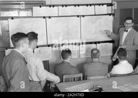 Mitarbeiter der Wetterdienststelle beim Sichten von Landkarten, Deutschland 1930er Jahre. Membro del personale di un ufficio meteorologico lavora con mappe, Germania 1930s. Foto Stock