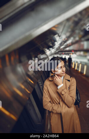 Donna cammina per le strade di Chicago in un mantello marrone Foto Stock