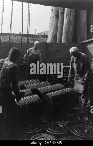 Lagerarbeiter der Rhenania Ossag Mineralölwerke AG DI AMBURGO das verladen Bitumenprodukt Mexphalt auf Schiffe, Deutschland 1930er Jahre. Warehousemen della Rhenania Ossag Mineraloelwerke AG ad Amburgo il carico di una nave con il bitume prodotto Mexphalt, Germania 1930s. Foto Stock