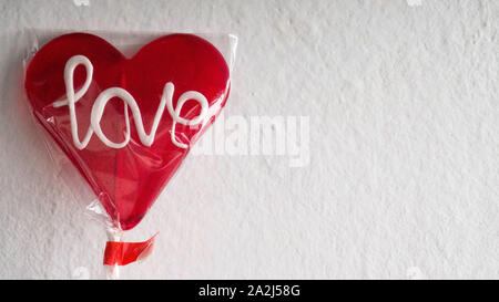 Lecca-lecca rosso a forma di cuore con un messaggio di amore Foto Stock