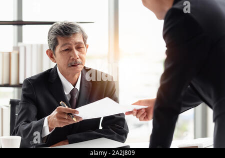 Il giovane imprenditore di inviare la relazione al suo boss a portata di mano in ufficio. Foto Stock