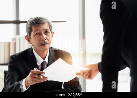 Il giovane imprenditore di inviare la relazione al suo boss a portata di mano in ufficio. Foto Stock