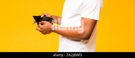 Vuoto in portafoglio uomo nero mani su sfondo giallo Foto Stock