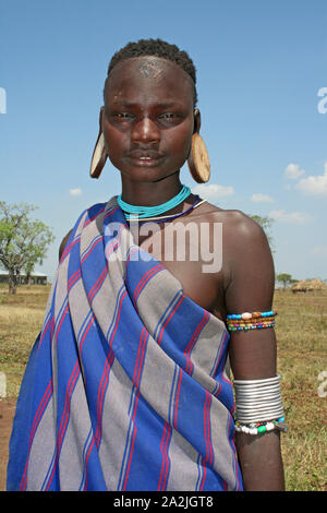 Mursi Tribeswoman indossare tappi per le orecchie Foto Stock