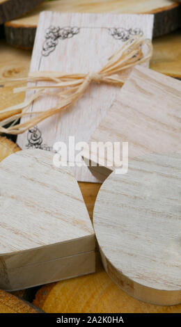 Messaggio di saluto in legno carta e un dono di chiusura di scatole di differenti forme sul moncone di legno Foto Stock