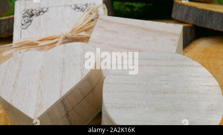 Messaggio di saluto in legno carta e un dono di chiusura di scatole di differenti forme sul moncone di legno Foto Stock