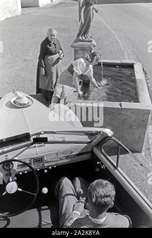 Die österreichische Schauspielerin Gusti Wolf erfrischt sich un einem Brunnen bei Ferien auf dem Lande, Deutschland 1930er Jahre. Attrice austriaca Gusti Wolf rinfrescante in corrispondenza di un pozzetto in vacanza in campagna, Germania 1930s. Foto Stock