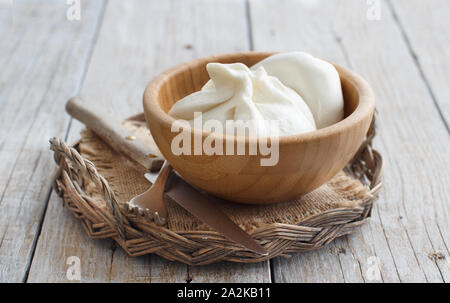 Formaggio italiano burrata con il pane su un sfondo di legno Foto Stock