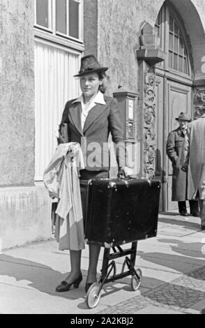 Eine Frau Mit einem Koffer auf Rollen bei der Messe Leipzig, Deutschland 1940er Jahre. Una donna con una valigia su ruote a Lipsia trade show, Germania 1940s. Foto Stock