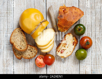 Scamorza, i pomodori e il pane su una tavola di legno Foto Stock