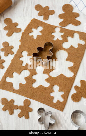 In casa impasto crudo per la produzione di biscotti di Natale su una bianca superficie di legno e a basso angolo di visione. Close-up. Foto Stock