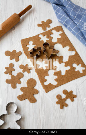 In casa impasto crudo per la produzione di biscotti di Natale su una bianca superficie di legno e a basso angolo di visione. Foto Stock