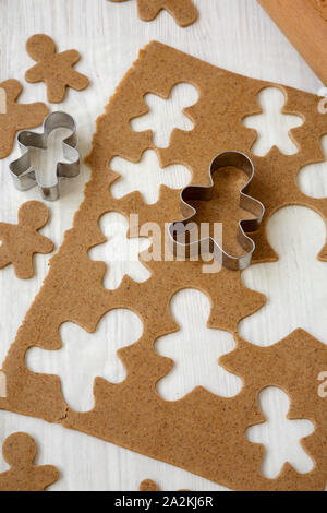 In casa impasto crudo per la produzione di biscotti di Natale su una bianca superficie di legno e a basso angolo di visione. Foto Stock