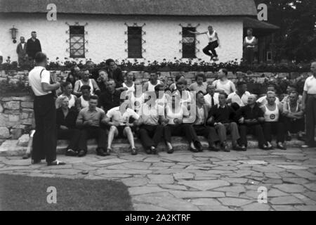 Musik und Tanz vor Waldhütten des KdF Sportheim Belzig in der Mark Brandenburg, Deutschland 1930er Jahre. La gente di cantare e ballare nella parte anteriore dei rifugi forestali presso il club sportivo a Belzig nel Brandeburgo, Germania 1930s. Foto Stock