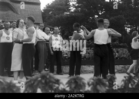 Musik und Tanz vor Waldhütten des KdF Sportheim Belzig in der Mark Brandenburg, Deutschland 1930er Jahre. La gente di cantare e ballare nella parte anteriore dei rifugi forestali presso il club sportivo a Belzig nel Brandeburgo, Germania 1930s. Foto Stock