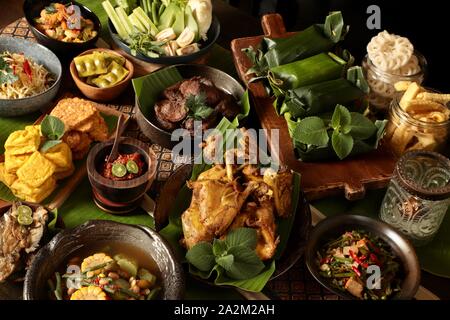 Nasi Timbel Rijsttafel. Sundanese tradizionale festa di riso avvolto in foglie di banana; servita con diversi contorni. Foto Stock