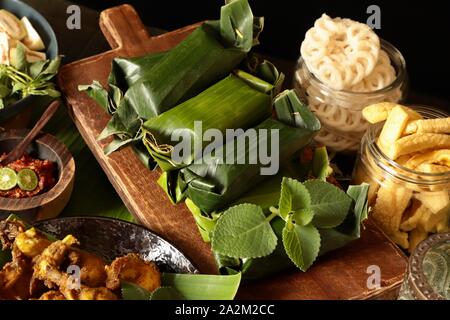 Nasi Timbel. Sundanese tradizionale piatto di riso di riso al vapore avvolto in foglie di banana e sagomata in registri. Foto Stock