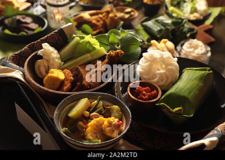 Nasi Timbel. Sundanese tradizionale festa di riso avvolto in foglie di banana; servita con diversi contorni. Foto Stock