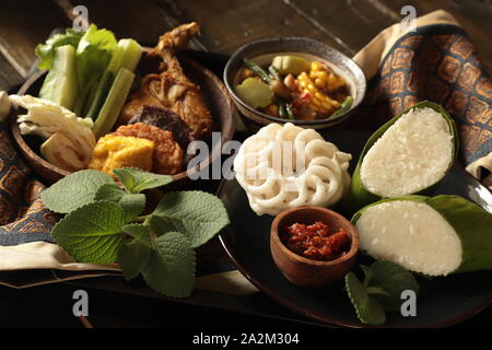 Nasi Timbel. Sundanese tradizionale festa di riso avvolto in foglie di banana; servita con diversi contorni. Foto Stock