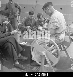 Original-Bildunterschrift: Freizeit des Matrosen: Matrosen beim Kartenspiel un deck an Bord eines Torpedoboots, Deutschland 1940er Jahre. Sailor's: il tempo libero giocando a carte sul ponte di una torpediniera, Germania 1940s. Foto Stock