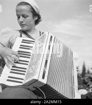 Eine junge Frau Mit einem Akkordeon, Deutschland 1930er Jahre. Una giovane donna di suonare la fisarmonica, Germania 1930s. Foto Stock